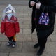 A Chinese boy is covered in a plastic bag for protection as he arrives from a train at Beijing Station on February 12, 2020 in Beijing, China.